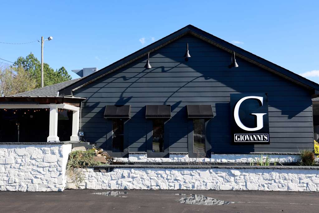 Front view of Gwan’s Italian restaurant entrance with signage, promoting grand opening on March 12