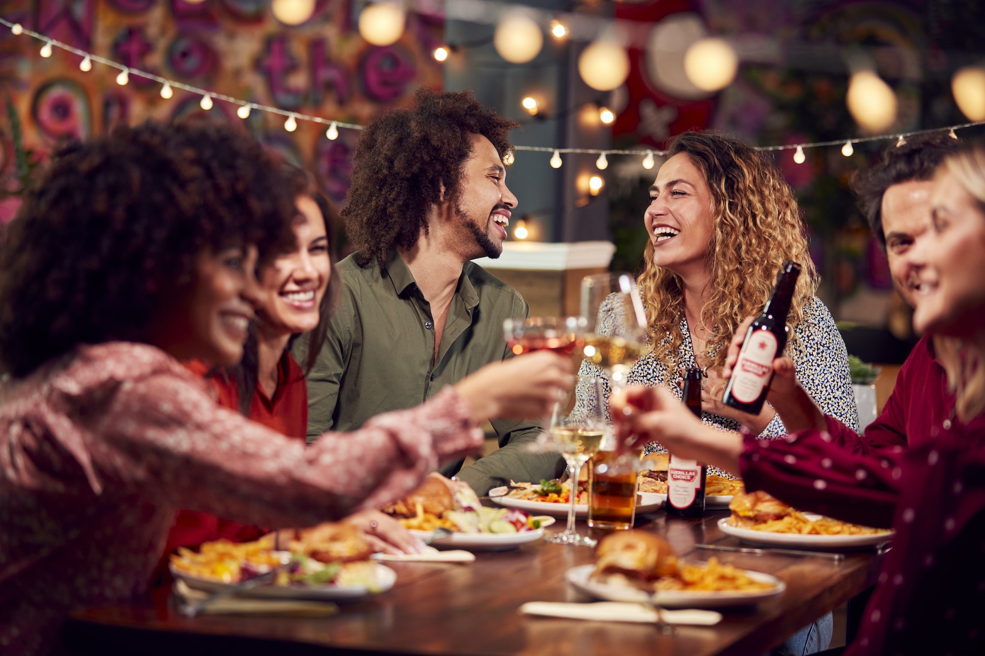 Group of friends laughing and sharing a meal together at a cozy table at Giovanni’s Italian restaurant