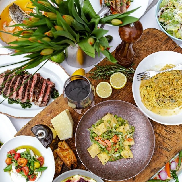 Table filled with authentic Italian food, seafood dishes, pasta, desserts, and drinks at Giovanni's Italian Restaurant in Greensboro NC