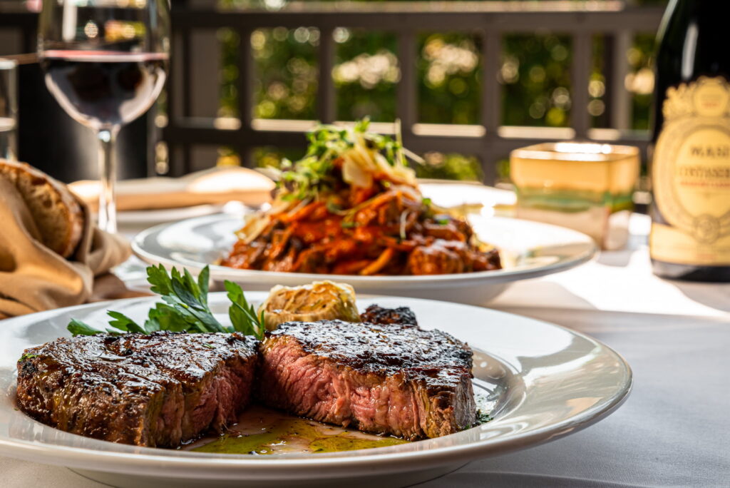 Premium Filet Mignon steak served at Giovanni's Italian Steakhouse near High Point NC with fine dining presentation and a glass of red wine.
