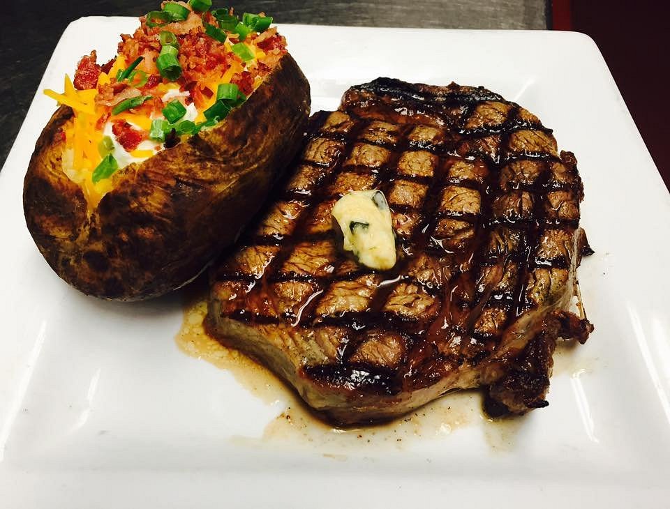 Filet Mignon steak with baked potato and fresh herbs