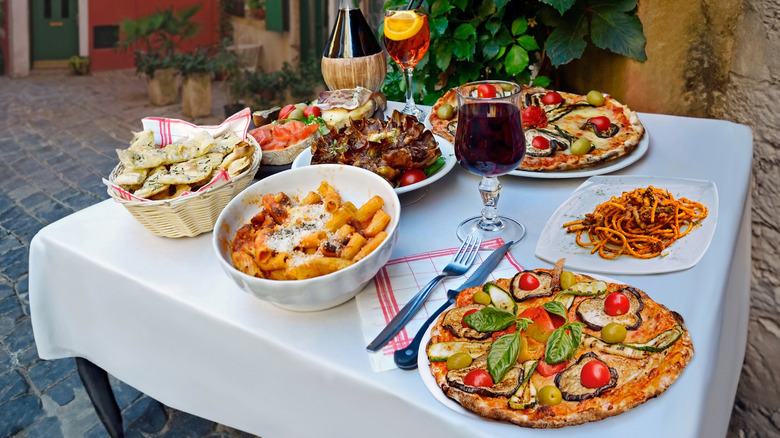 Italian dining table set with food dishes and wine for a shared meal