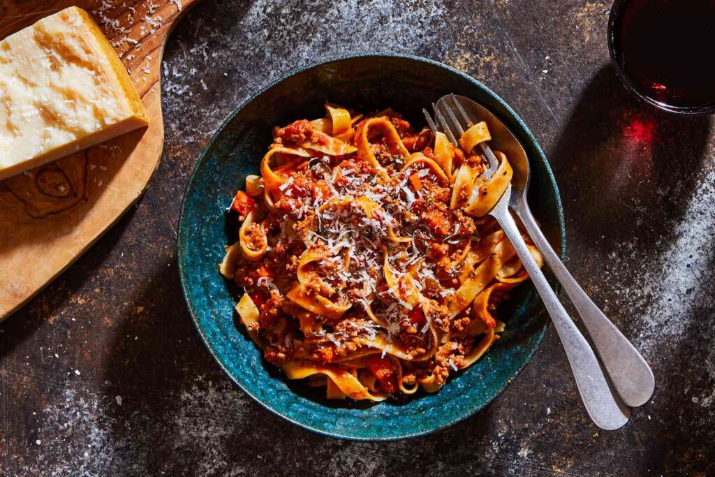 Italian pasta with meat sauce served with red wine