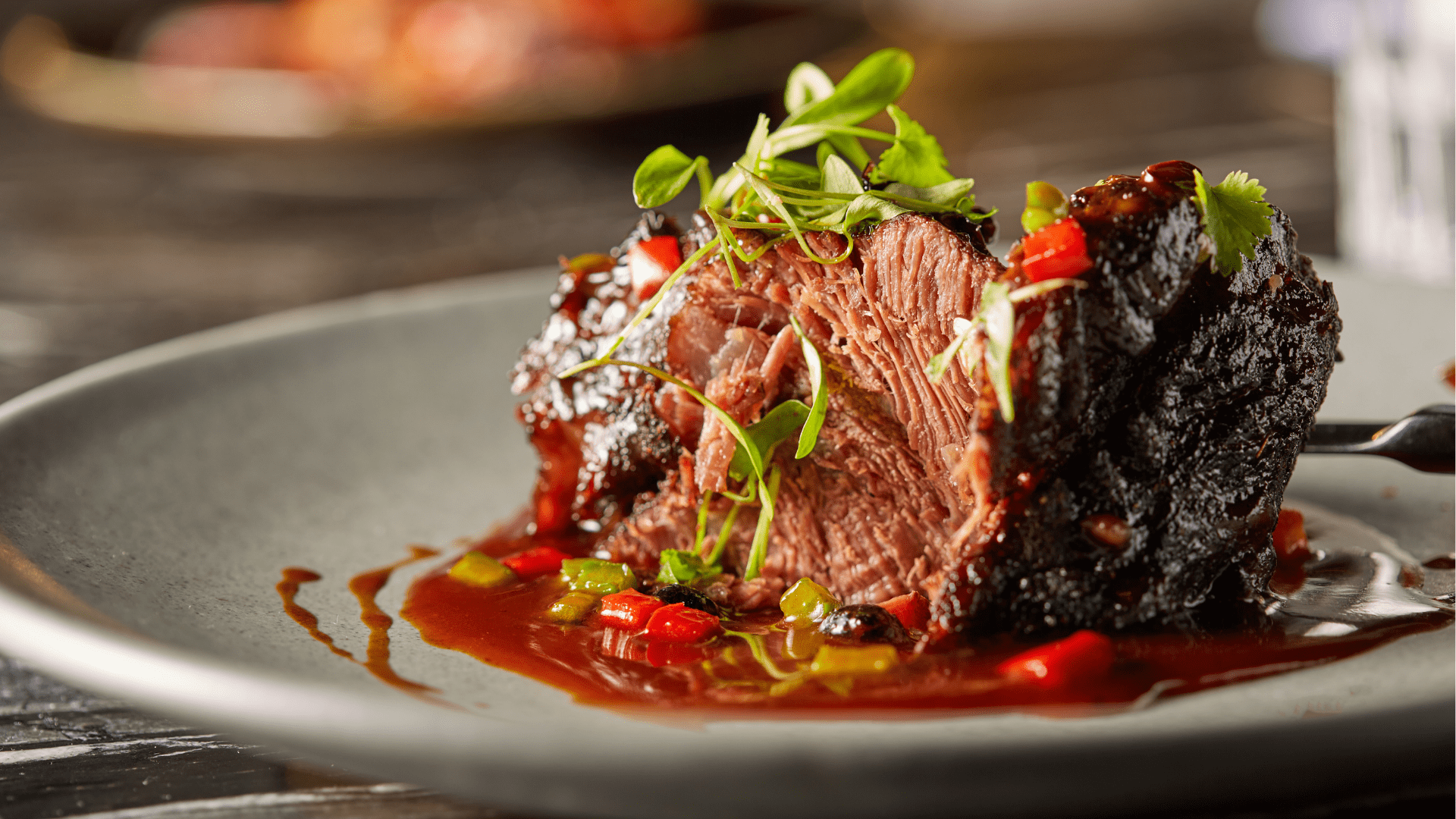 Cooked Italian-style meat served with rich brown sauce on a white plate